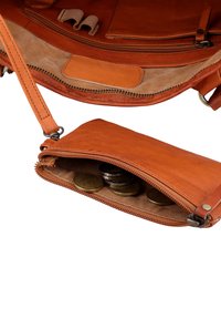 Small brown leather pouch with zipper partially open, containing Euro coins, attached to matching brown leather bag interior.