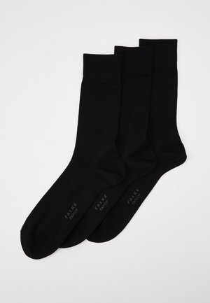 Crne pamučne čarape u pakiranju od tri para. Imaju rebrasti rub i glatku teksturu. Svaka čarapa ima "FALKE" branding blizu gležnja.