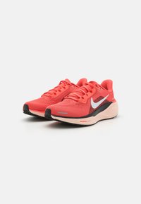 Baskets de course en mesh rouges avec une semelle noire, ornées d'un logo Nike blanc, d'un dessus texturé et de lacets contrastants. Technologie Air Zoom mentionnée.