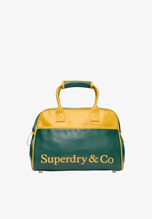 Sac de sport en cuir vert et jaune avec des poignées courtes et le texte "Superdry & Co" inscrit à l'avant en lettres jaunes.