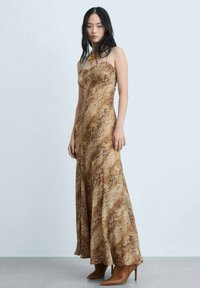 Abito lungo senza maniche con un motivo astratto marrone e oro, realizzato in tessuto leggero, con una silhouette svasata e scollatura a cuore.