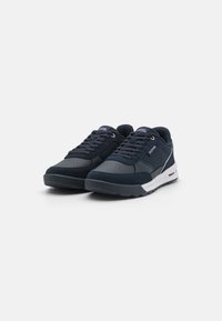 Sneakers blu navy con un mix di pelle scamosciata e materiali sintetici. Presentano un collo imbottito, un design con lacci e una suola intermedia bianca.