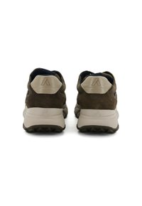 Zapatillas deportivas de ante marrón con lengüetas de talón beige y suelas gruesas blancas, mostradas desde la parte de atrás sobre un fondo blanco.