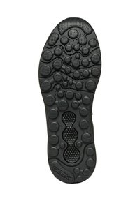 Semelle de chaussure en caoutchouc noir avec une surface texturée comportant des motifs circulaires et ovales, y compris des trous de ventilation et un logo de marque en relief.