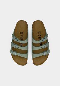 Πράσινα σανδάλια με τρεις ιμάντες και μεταλλικά αγκράφια· υφασμένο πέλμα· καφέ λαστιχένια σόλα· μέγεθος 37 εμφανίζεται στην εσωτερική σόλα.
