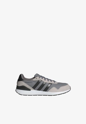 Baskets Adidas gris et noires avec une tige en mesh et en daim, une semelle blanche et trois rayures noires sur le côté.