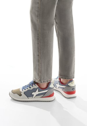 Scarpe sportive con una parte superiore grigio chiaro, blu e beige con accenti bianchi, materiali texturizzati e un tacco rosso. Design con stringhe e suola con motivo.