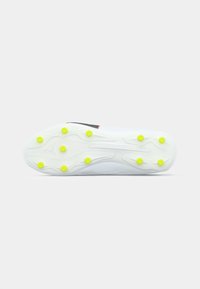 Football cleat with a white rubber outsole, featuring yellow studs, a textured surface, and a black accent stripe.