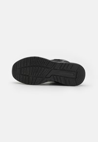 Semelle extérieure noire de chaussure de sport avec caoutchouc texturé pour une meilleure adhérence, présentant un motif de bande de roulement et des bords biseautés pour une traction et une durabilité accrues.