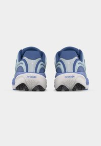 Ζευγάρι μπλε και λευκά αθλητικά παπούτσια New Balance, εμφανιζόμενα από πίσω, με επενδυμένες σόλες που φέρουν την ένδειξη «INFINION».