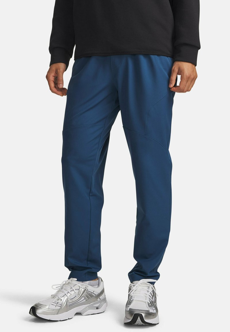 Pantalon de sport bleu marine à coupe fuselée, confectionné en tissu léger. Doté de détails en panneaux et d'une taille élastique.