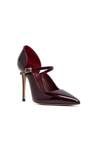 Zapato de Mary Jane de tacón alto en rojo oscuro brillante, con punta afilada, correa de tobillo con hebilla y tacón de aguja color beige sobre fondo blanco.