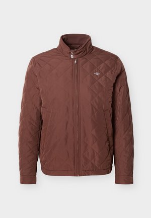 Brown quilted jacket with stand-up collar, zipper closure, and side pockets. Soft texture with diamond pattern stitching.