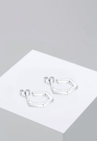 Pendientes geométricos de plata con forma hexagonal, con un acabado pulido, cierre de tipo stud y marca 925 grabada.