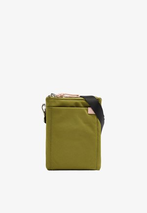 Prostokątna zielona na oliwkach torba na ramię z czarnym paskiem, przednią kieszenią oraz zamknięciem na suwak u góry z różowym sznureczkiem.