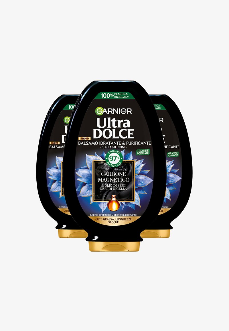Tre bottiglie nere di balsamo Garnier Ultra Dolce con design floreale blu, dettagli dorati e un'etichetta che indica il 97% di ingredienti naturali.