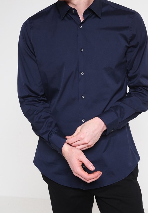Ciemnogranatowa koszula zapinana na guziki, wykonana z gładkiego materiału, z wyraźnym kołnierzykiem, długimi rękawami i delikatnym połyskiem. Widoczne czarne guziki.
