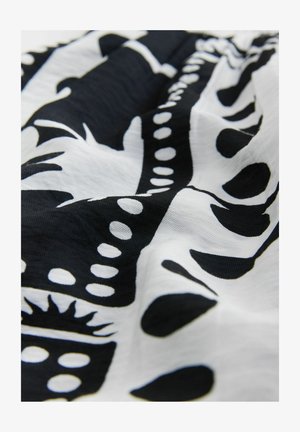 Juoda ir balta medžiaga su abstrakčiais raštais, kuriuose yra formų ir taškinių detalių. Medžiaga atrodo lengva ir tekstūruota.