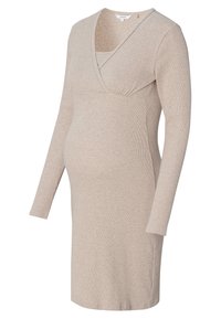 Beige lange mouw zwangerschapsjurk van zachte ribstof met een crossover V-halsontwerp en geplooide details onder de buste voor comfort.