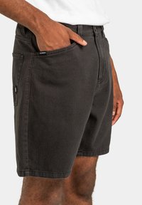 Zwarte denim shorts met een rechte snit, voorzien van voor- en zijzakken. Subtiele merkteken op de zak, gestructureerde stof.