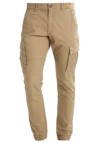 Lichtbeige cargobroek gemaakt van duurzaam katoen. Kenmerken zijn onder andere elastische boorden, zijzakken en een ontspannen pasvorm.