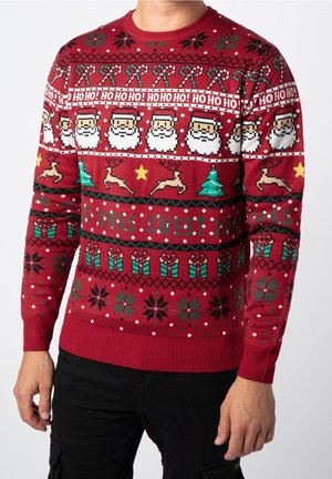 Czerwony sweter świąteczny z pikselowanymi twarzami Mikołaja, laski cukrowe, renifery, choinki, prezenty, gwiazdki i wzory z napisem „HO HO HO!”.