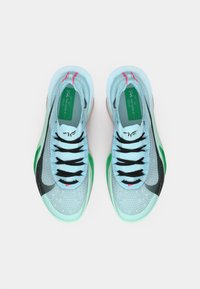 Light blue athletic shoes with black laces, green accents, and a black swoosh logo. Textured mesh material and a smooth outsole.