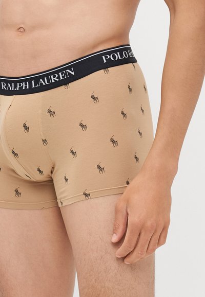 Beige színű boxer alsónadrág, pamut keverékből, fekete derékkal. Az anyagon ismétlődő fekete polo ló minta található.