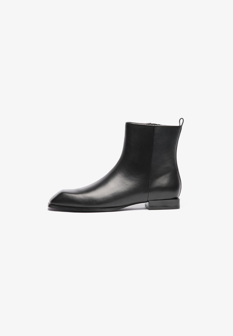 Black leather ankle boot with a smooth texture, pointed toe, minimalistic design, and a low square heel. Includes a rear pull tab for ease of wear.