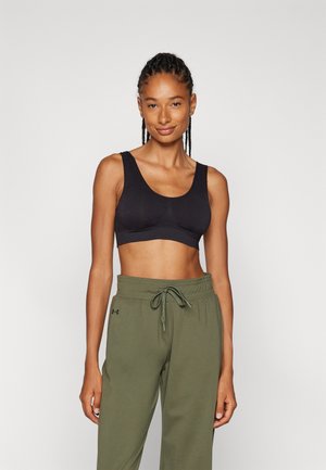 Soutien-gorge de sport noir avec un décolleté large en U et des bretelles épaisses, associé à un pantalon de jogging vert olive avec une taille élastique et un cordon de serrage.