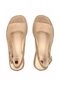 Chaussures en suède beige avec un bout carré et une semelle en caoutchouc. Présentent une boucle latérale et un petit accent rouge près de l'étiquette de la marque. Intérieur lisse.