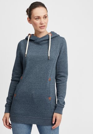Blå hettegenser laget av mykt stoff, med en cowl-neck, kremfargede snorer og brune skinnakenter. Lange ermer og en avslappet passform.