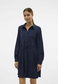 Marineblauwe jurk met lange mouwen, knoopsluiting aan de voorkant en gathers in de taille. Zachte stof met een gladde textuur en kraagdetail.