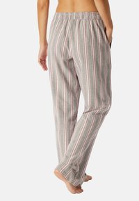 Pantaloni da pigiama a righe verde, rosa e bianco, con una vestibilità rilassata, cintura elastica e tasche laterali. Tessuto morbido e testurizzato.