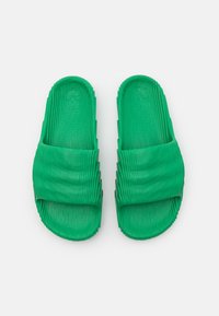 Grønne gummisandaler med rillestruktur, åpen tå-design og bred stropp. Har en formet såle for komfort.
