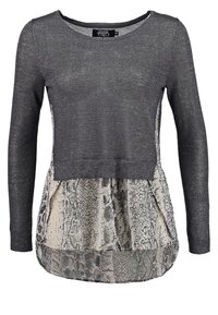 Haut à manches longues avec un haut en tricot texturé gris foncé et un bas peplum en imprimé serpent beige ; encolure arrondie et coupe décontractée.