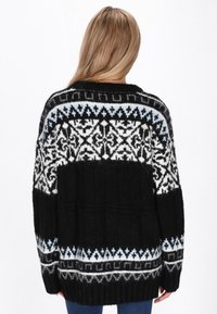 Grob gestrickter schwarzer Pullover mit komplexen weißen und hellblauen geometrischen Mustern. Verfügt über einen gerippten Saum, lange Ärmel und eine lässige Passform.