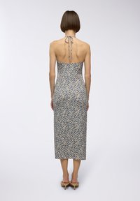 Abito midi a stampa floreale in crema e blu, design aderente con scollo all'americana e schiena scoperta, caratterizzato da un orlo dritto e una texture di tessuto liscia.