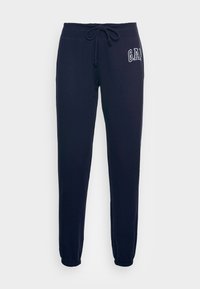 Marinblå sweatpants med dragsko i midjan, elastiska ärmslut och "GAP"-logotyp broderad på vänster höft. Mjuk bomullsblandning.