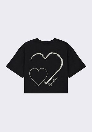 Zwart cropped t-shirt met twee omrande harten in het wit op de achterkant, met een handtekeningdetail dicht bij de zoom. Zachte katoen materiaal.