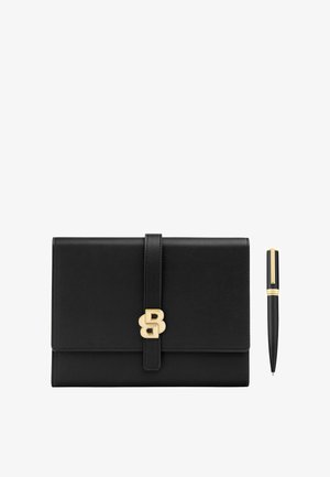 Black leather clutch with gold clasp beside a black and gold ballpoint pen on a white background.