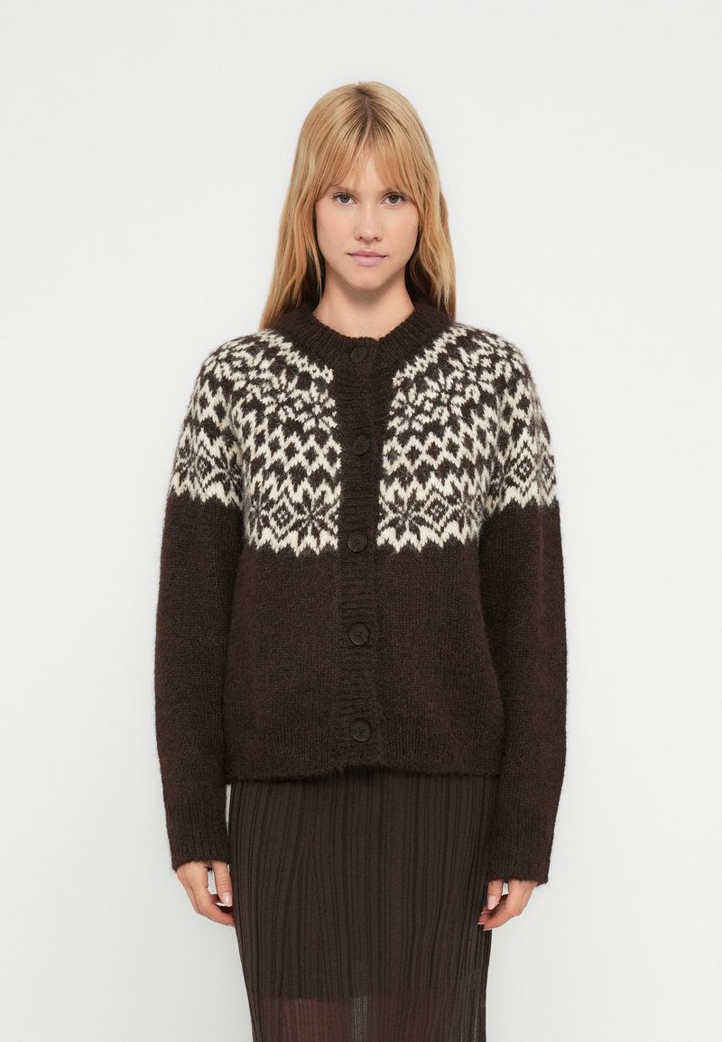 Brown knitted cardigan featuring a white patterned yoke, round collar, front buttons, and long sleeves. Soft texture with loose fit.