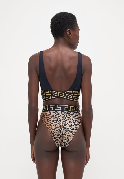 Tofarget badedrakt med en marineblå topp med lav rygg og bunn med leopardmønster og gull geometrisk bånd i midjen.
