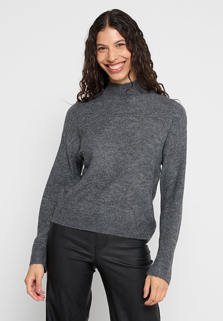 Grauer Strickpullover mit hohem Kragen, langen Ärmeln und einer lockeren Passform. Der Stoff hat eine weiche Textur und ein dezentes meliertes Muster.