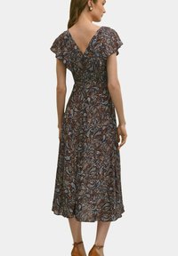 Sukienka midi w kwiatowy wzór w odcieniach ciemnoniebieskim, brązowym i kremowym. Posiada falbaniaste rękawy i dekolt w kształcie litery V na plecach. Gładka struktura tkaniny.