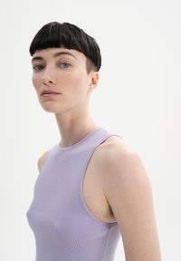 Mouwloze lavendel tanktop in een geribbelde brei stof, met een hoge halslijn en een aansluitende snit. Soepele textuur, minimalistisch ontwerp.