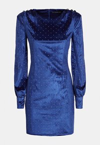 Robe en velours bleu avec manches longues, encolure arrondie et clous décoratifs sur l'ensemble. Présente une fermeture éclair dans le dos et des épaules bouffantes.