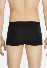 Schwarze Baumwoll-Boxershorts mit einem strukturierten schwarzen Bund. Das Design bietet eine enge Passform und gerade Beinausschnitte, aus glattem Material.
