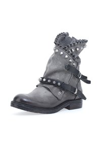 Gray leather ankle boot with black straps and silver studs, featuring a folded top edge with black rounded embellishments.