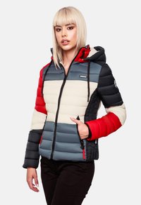 Veste rembourrée en bleu, crème, rouge et noir ; elle dispose d'une fermeture éclair, d'une capuche avec cordons de serrage et de poches latérales avec des accents contrastants.